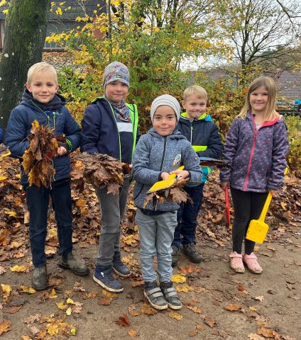 Kinder mit Laub in den Händen