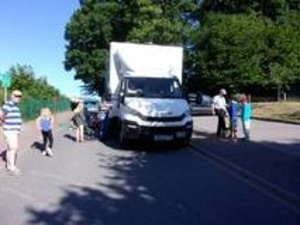 Kinder stehen um einen weißen LKW